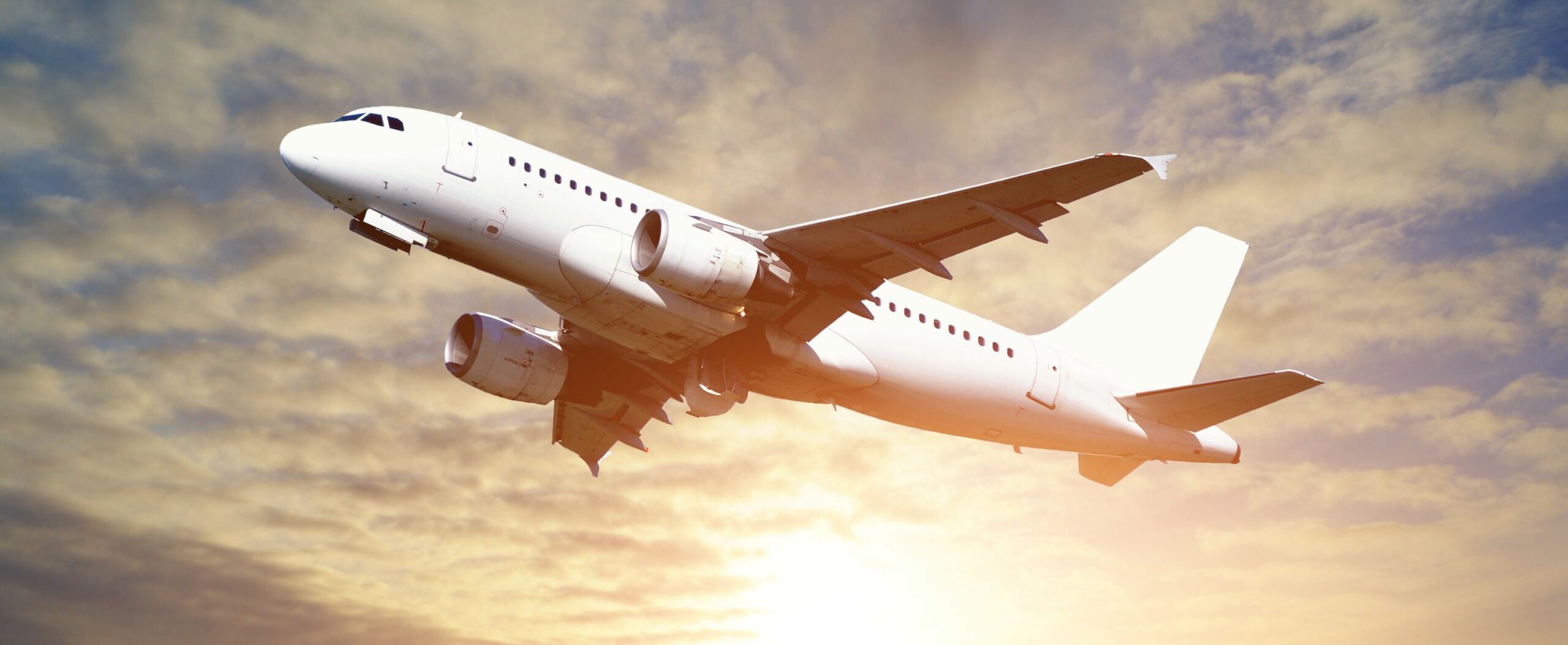 White flying airplane in the sunlight